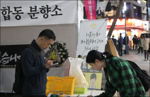 '세월호 인양' 촉구 서명운동에 한 시민이 참여하는 모습(2015.4.15) / 사진.평화뉴스 김영화 기자