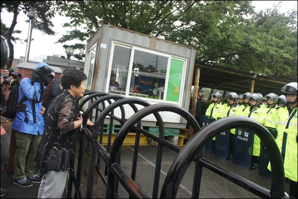 차씨가 내려오기 전 체포영장을 집행하기 위해 공장 안에 대기 중인 경찰병력에게 차씨의 어머니가 소리를 치고 있다(2015.7.8) / 사진.평화뉴스 박성하 인턴기자