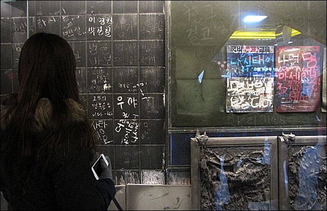 대구지하철참사 사고 현장을 보존한 추모벽 앞에 선 시민(2015.12.28) / 사진.평화뉴스 김영화 기자