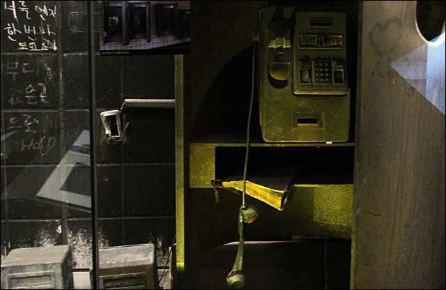 검은 재가 가득 쌓인 전화부스(2015.12.28) / 사진.평화뉴스 김영화 기자