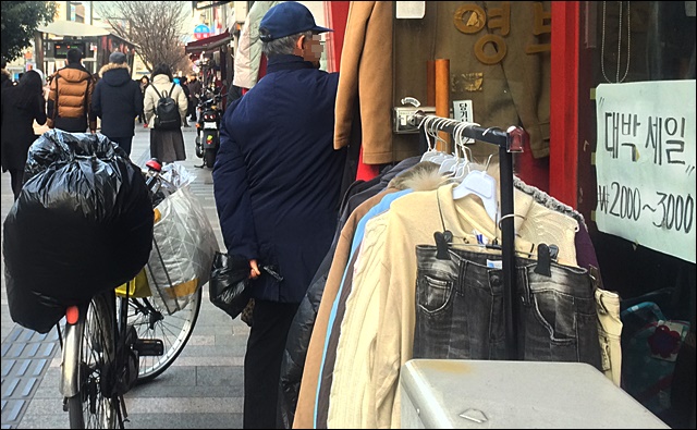자전거를 세워놓고 교동에서 구제옷을 구경하는 한 할아버지(2016.1.11) / 사진.평화뉴스 김영화 기자