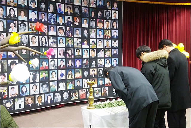 희생자 영정사진 앞에 묵념하는 추모식 참석자들(2016.2.18) / 사진.평화뉴스 김지연 수습기자