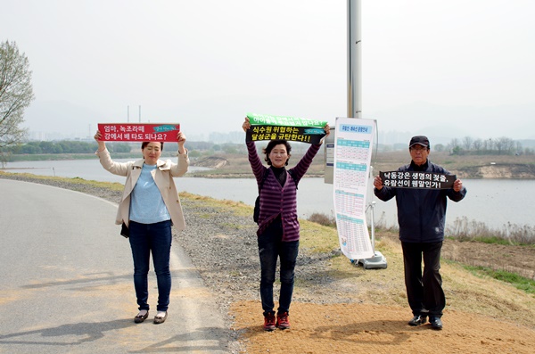 낙동강 살리기 대책위 소속 회원들이 유람선 사업을 강행하는 달성군을 규탄하는 손피켓을 들고 서있다. "다 죽어가는 강위에서 뱃놀이사업, 자식들께 부끄럽지 않은가?" ⓒ대구환경운동연합