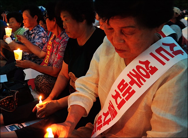 어르신들이 집회에 참가해 서로 촛불을 켜주고 있다(2016.7.14) / 사진.평화뉴스 김영화 기자