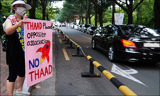 주민 배미영(39)씨가 행사장으로 들어오는 차량을 향해 'NO THAAD' 피켓을 보이고 있다.(2016.7.27.두류운동장 앞) / 사진.평화뉴스 김지연 기자
