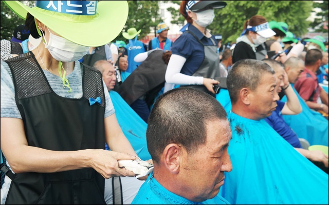 자원봉사자들이 주민들의 머리를 깎고 있다(2016.8.15) / 사진.평화뉴스 김지연 기자