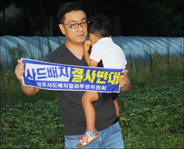 아이를 안고 행사에 참여한 한 아버지(2016.8.27) / 사진.평화뉴스 김영화 기자