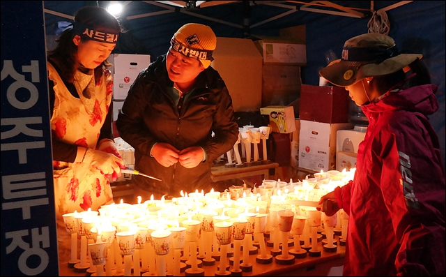 자원봉사자들이 집회에 쓸 촛불을 만들어 나눠주고 있다(2016.10.16) / 사진.평화뉴스 김지연 기자