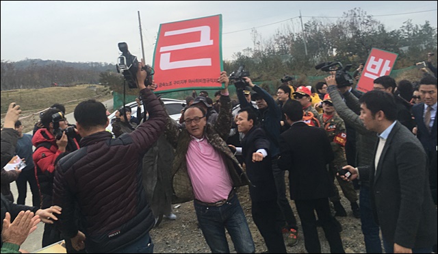 지지자들에게 둘러싸여 퇴진 피켓을 들고 도망가는 시위자들(2016.11.14) / 사진.평화뉴스 김영화 기자