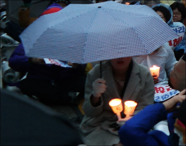 우산을 쓰고 촛불을 켜 어둠을 밝히는 시민(2016.11.26) / 사진.평화뉴스 김지연 기자
