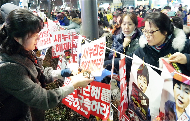 곽상도 의원 지역사무소 앞에서 "박근혜 구속", "새누리 해체" 등 피켓을 달고 있는 시민들(2016.12.24) / 사진.평화뉴스 윤명은 인턴기자