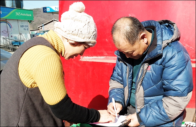 공항이전 반대 서명을 받고 있는 주민들(2017.1.10) / 사진.평화뉴스 김지연 기자