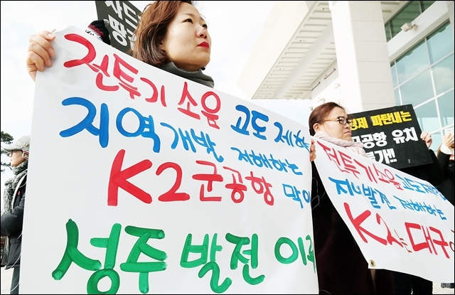 설명회에 앞서 공항반대 피켓을 들고 있는 주민(2017.1.12) / 사진.평화뉴스 김지연 기자