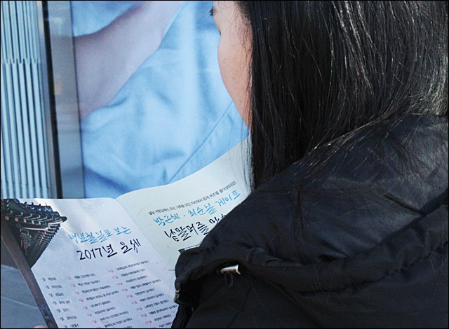 귀성길에 오른 한 시민이 촛불 책자를 읽고 있다(2017.1.26) / 사진.평화뉴스 김영화 기자