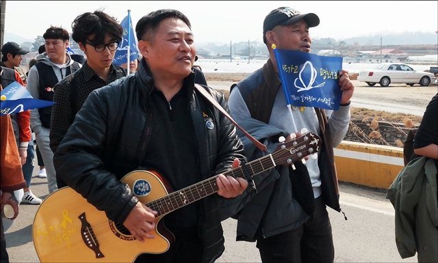 기타연주와 함께 노래를 부르며 즐겁게 행진하는 참가자들(2017.3.18) / 사진.평화뉴스 김지연 기자