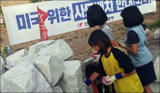 아이들이 마을 입구에서 '평화기원' 돌탑을 쌓고 있다 / 사진.사드원천무효종합상황실 제공