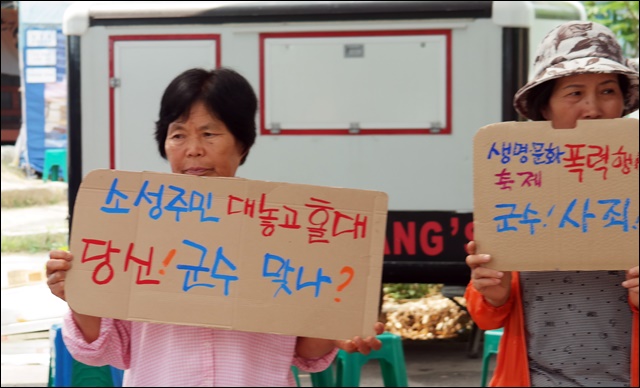 군수를 기다리며 회관 앞에서 피켓을 들고 있는 주민들(2017.6.1) / 사진.평화뉴스 김지연 기자