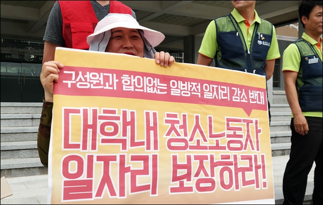 "대학 청소노동자 일자리 보장"을 촉구하는 피켓을 든 청소노동자(2017.6.20) / 사진.평화뉴스 김지연 기자