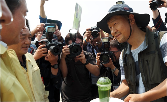 (왼쪽)이낙연 총리에게 '녹조라떼'를 건네고 있는 지역 환경단체 관계자(2017.6.21) / 사진.평화뉴스 김지연 기자