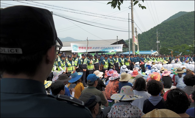 주민들이 경찰에 둘러싸인 채 기도회를 열고 있다(2017.6.27. 초전면 소성리) / 사진. 평화뉴스 김지연 기자