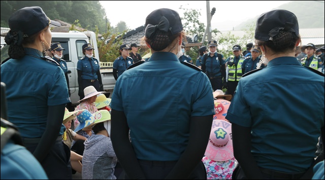 도로 위에서 농성 중인 주민들을 둘러싼 경찰(2017.7.12. 소성리 마을회관 앞) / 사진. 평화뉴스 김지연 기자