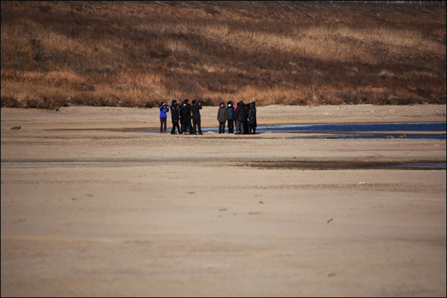 낙동강 네트워크 소속 단체 회원들이 낙동강으로 걸어들어가, 되돌아 온 모래톱 위를 밟아보고 있다. ⓒ 대구환경연합 정수근