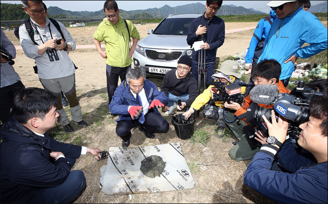 박창근 교수가 낙동강 한가운데 바닥에서 퍼온 저질토를 살펴보며 기자들에게 설명하고 있다 ⓒ 이성수