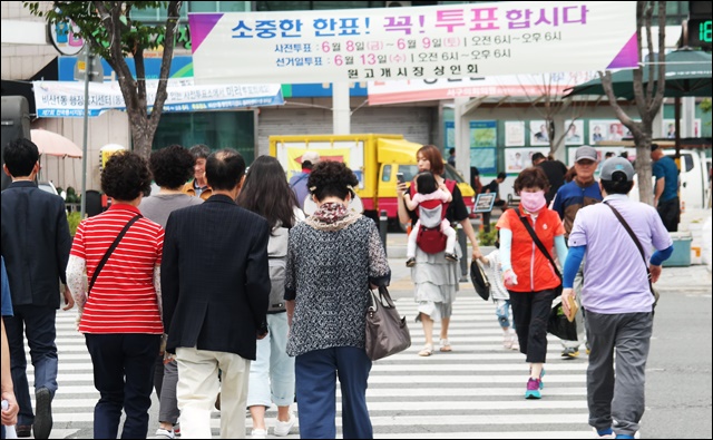 사전투표 안내 현수막 아래 길을 건너는 시민들(2018.6.9) / 사진. 평화뉴스 김지연 기자