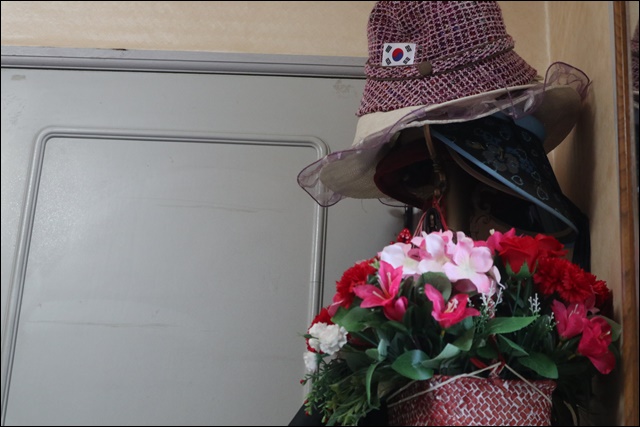 할머니 침대 옆에 걸린 태극기 모자와 꽃다발(2019.1.30) / 사진.평화뉴스 김영화 기자