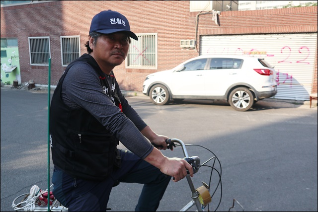 가요교실을 하는 세입자 김성진씨가 자전거로 순찰 중이다(2019.5.24) / 사진.평화뉴스 김영화 기자