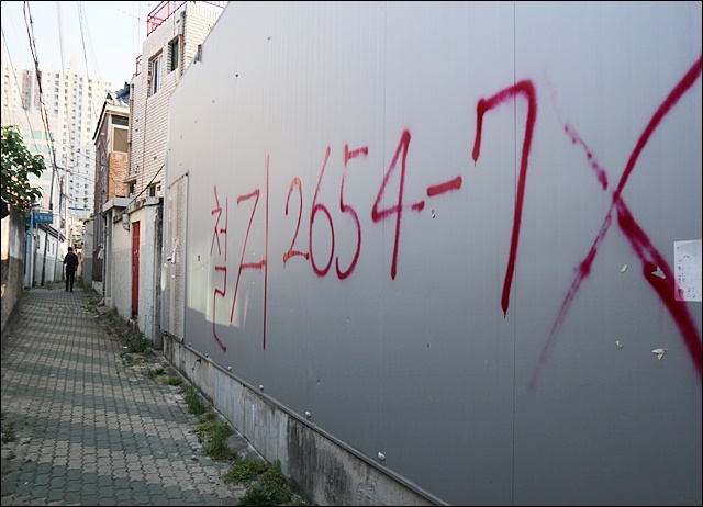 아파트로 둘러싸인 남산동 재건축 현장을 지나는 한 주민(2019.5.24) / 사진.평화뉴스 김영화 기자