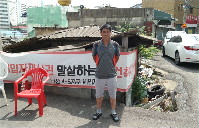 정인기 이주대책위원장이 자신의 가게 앞에 서있다(2019.7.23) / 사진.평화뉴스 한상균 수습기자