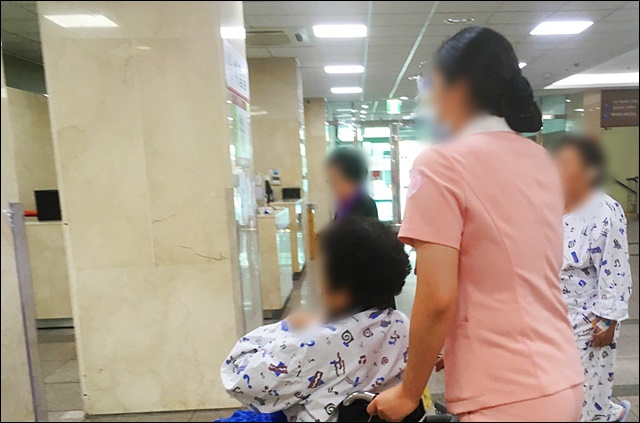 환자의 휠체어를 끌고 가는 경북대병원 한 간호사(2019.10.17) / 사진.평화뉴스 김영화 기자