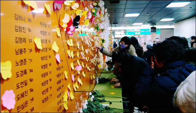 대구도시철도 1호선 중앙로역에 마련된 '기억의 공간'을 찾은 유족과 시민들이 헌화에 이어 추모 메시지를 벽에 붙이고 있다(2020.2.18) / 사진.평화뉴스 한상균 기자