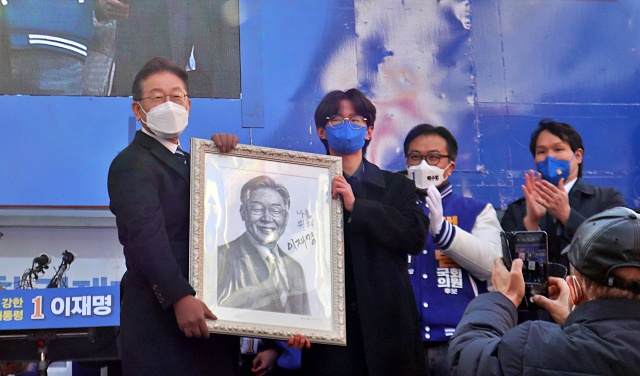 이 후보가 자화상을 그린 학생과 사진을 찍고 있다.(2022.2.15) / 사진.평화뉴스 김영화 기자