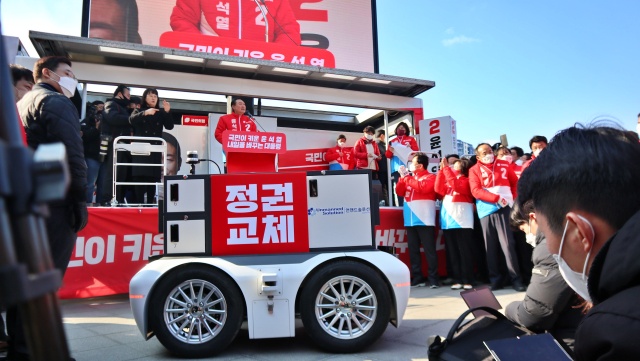 '정권교체' 로봇에서 마이크를 받은 윤 후보가 발언 중이.(2022.2.15) / 사진.평화뉴스 김영화 기자