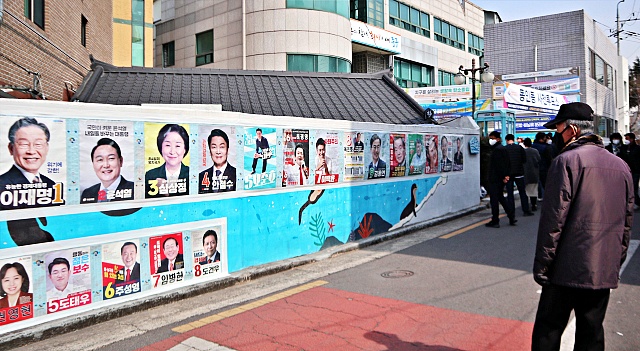 사전투표소 앞 대선후보들 벽보를 보고 있는 대구시민(2022.3.4) / 사진.평화뉴스 김영화 기자