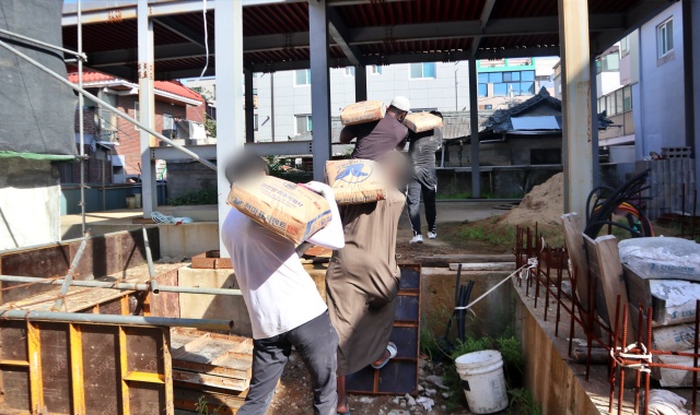 뼈대만 세워진 공사장에 시멘트를 옮기는 무슬림들(2022.8.22) / 사진.평화뉴스 김영화 기자