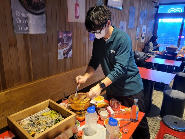 대구 종로 한 포차 식탁을 청소하는 남영욱씨(2022.12.31) / 사진. 평화뉴스 정준민 인턴기자