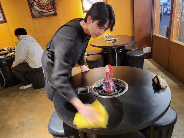 앞치마를 입고 식탁을 닦는 김동영(23)씨(2022.12.31) / 사진. 평화뉴스 정준민 인턴기자