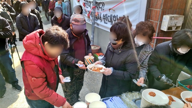 공사가 멈춘 대구 북구 대현동 이슬람사원 부지 앞. 대현동 주민비대위가 두번째 돼지고기 국민잔치를 열었다. 주민들이 돼지수육을 접시에 담고 있다.(2023.2.2) / 사진.평화뉴스 김영화 기자