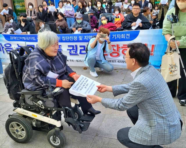 박명애 대표가 정연걸 대구인권위 소장에게 집단진정서를 건냈다.(2023.4.11) / 사진.평화뉴스 김영화 기자