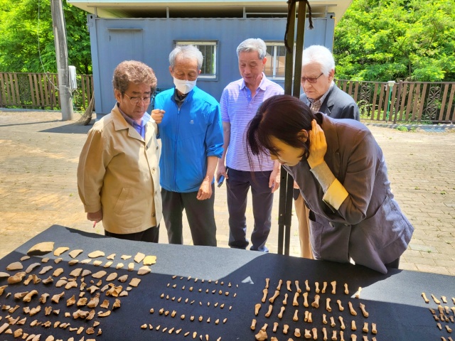 코발트광산 유족들과 임나혁 진화위 전문위원이 유골을 보고 있다.(2023.5.25) / 사진. 평화뉴스 정준민 기자