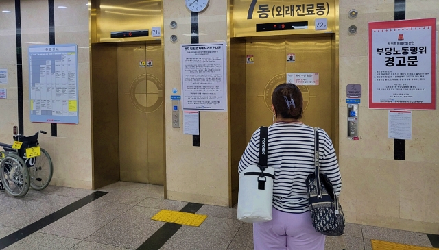 경북대병원 파업 첫날 본원에서 파업 안내문을 읽는 시민(2023.10.11) / 사진. 평화뉴스 정준민 기자