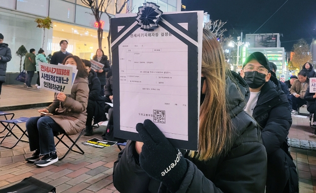 전세사기 피해자 결정문을 들고 있는 시민(2023.12.5) / 사진. 평화뉴스 정준민 기자