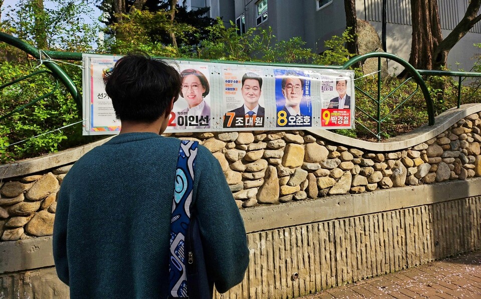 한 유권자가 수성구 지산청구타운 앞에 걸린 선거공보물을 보고 있다.(2024.4.7) / 사진.평화뉴스 정준민 기자