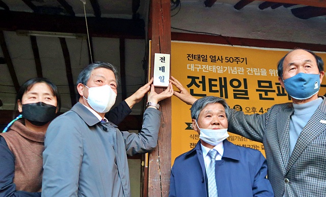 전태일 열사의 대구 남산동 고향집 마당 기둥에 50주기 하루 전 날 '전태일기념관' 건립을 위한 '전태일 문패걸이' 행사가 열렸다. 전태일 이름이 새겨진 문패를 참석자들이 걸고 있다(2020.11.12) / 사진.평화뉴스 김영화 기자