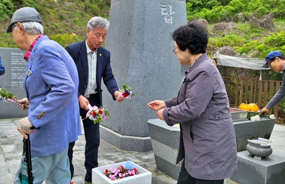 코발트광산 민간인 학살 희생자들의 위령탑 앞에서 유족들이 아버지와 어머니에게 걸 카네이션을 받고 있다.(2024.5.8) / 사진.평화뉴스 김영화 기자 