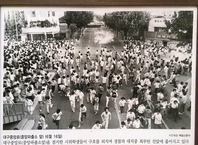 1987년 6월 옛 대구 중앙파출소 앞 시위 학생들이 구호를 외치며 경찰과 대치 중 최루탄을 피해 도망가고 있다. '6.10민주항쟁 34돌 사진전(매일신문사)'(2021.6.10.2.28기념공원) / 사진. 평화뉴스 김영화 기자