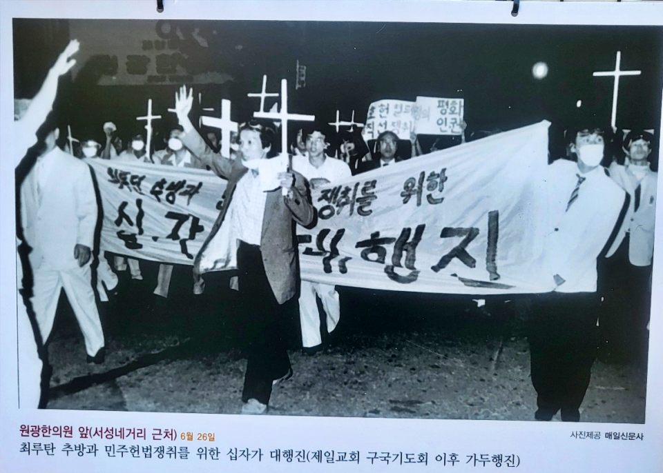 1987년 6월 26일 원광한의원 앞 서성네거리 근처에서 제일교회 구국기도회 이후 '최루탄 추방과 민주헌법쟁취를 위한 십자가 대행진'을 펼치고 있다.(2024.6.10 '1987년 대구의 6월 항쟁 사진전'. 대구 동성로 민주광장 - 사진 제공. 매일신문사) / 사진.평화뉴스 김영화 기자